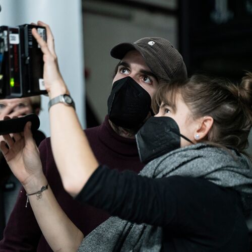 Two people look at a camera