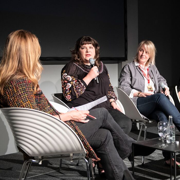 Five women on stage during a panel discussion